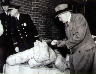 Commissioner Harry J. Anslinger inspects a drug seizure